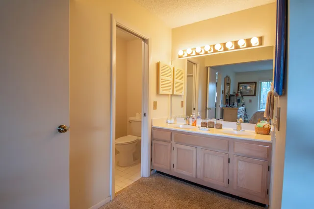 a bathroom with a double vanity sink and mirror with shower
