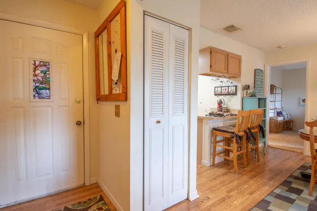 a living room with furniture a dining table and a refrigerator