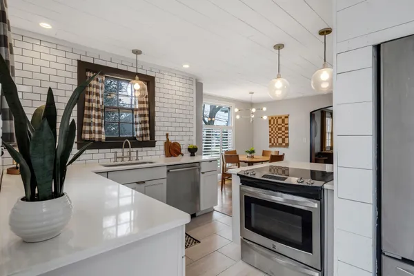 a kitchen with stainless steel appliances granite countertop a sink a stove and a wooden floors