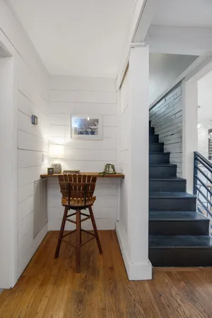 a view of a hallway with wooden floor and a cabinet