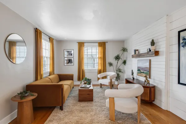 a living room with fireplace furniture and a large window