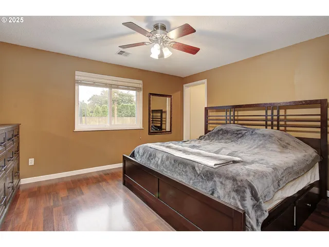 a bedroom with a large bed and a ceiling fan