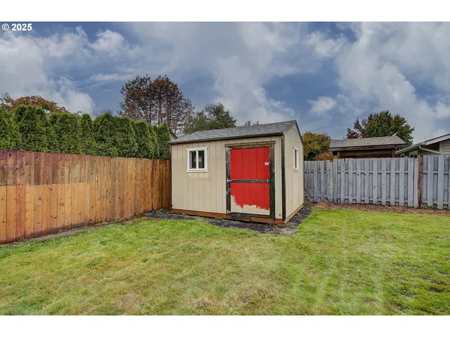 a view of backyard with wooden fence
