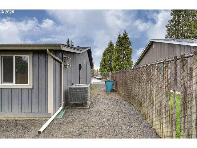 a view of a house with a yard and wooden fence