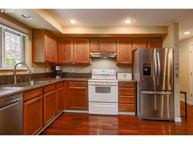 a kitchen with a refrigerator sink and cabinets