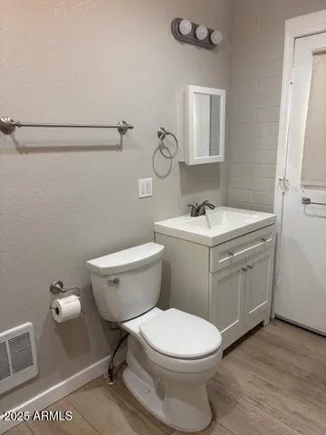 a bathroom with a toilet sink and mirror