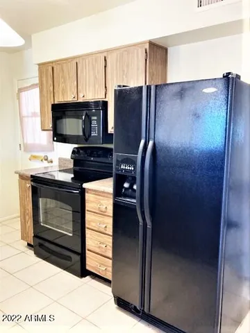 a kitchen with stainless steel appliances granite countertop a refrigerator stove and microwave