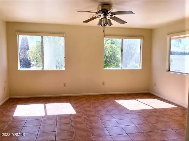 a view of a big room with windows and chandelier fan