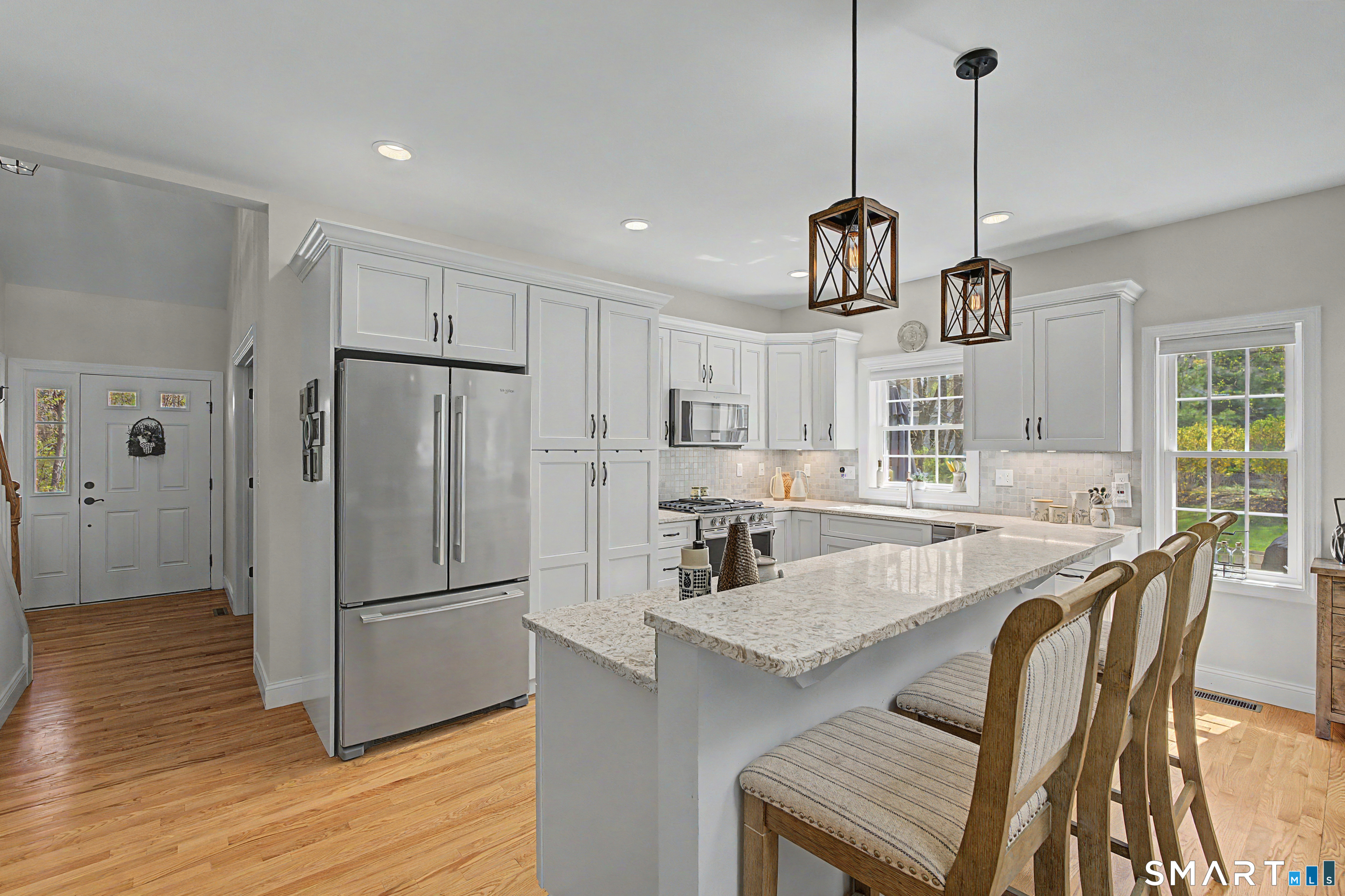 211 Meadowbrook Road, Unit 211 Oxford, CT 06478 - Photo 11 of 38 Generous breakfast bar offers ample seating-perfect for casual dining, morning coffee, or gathering with guests.