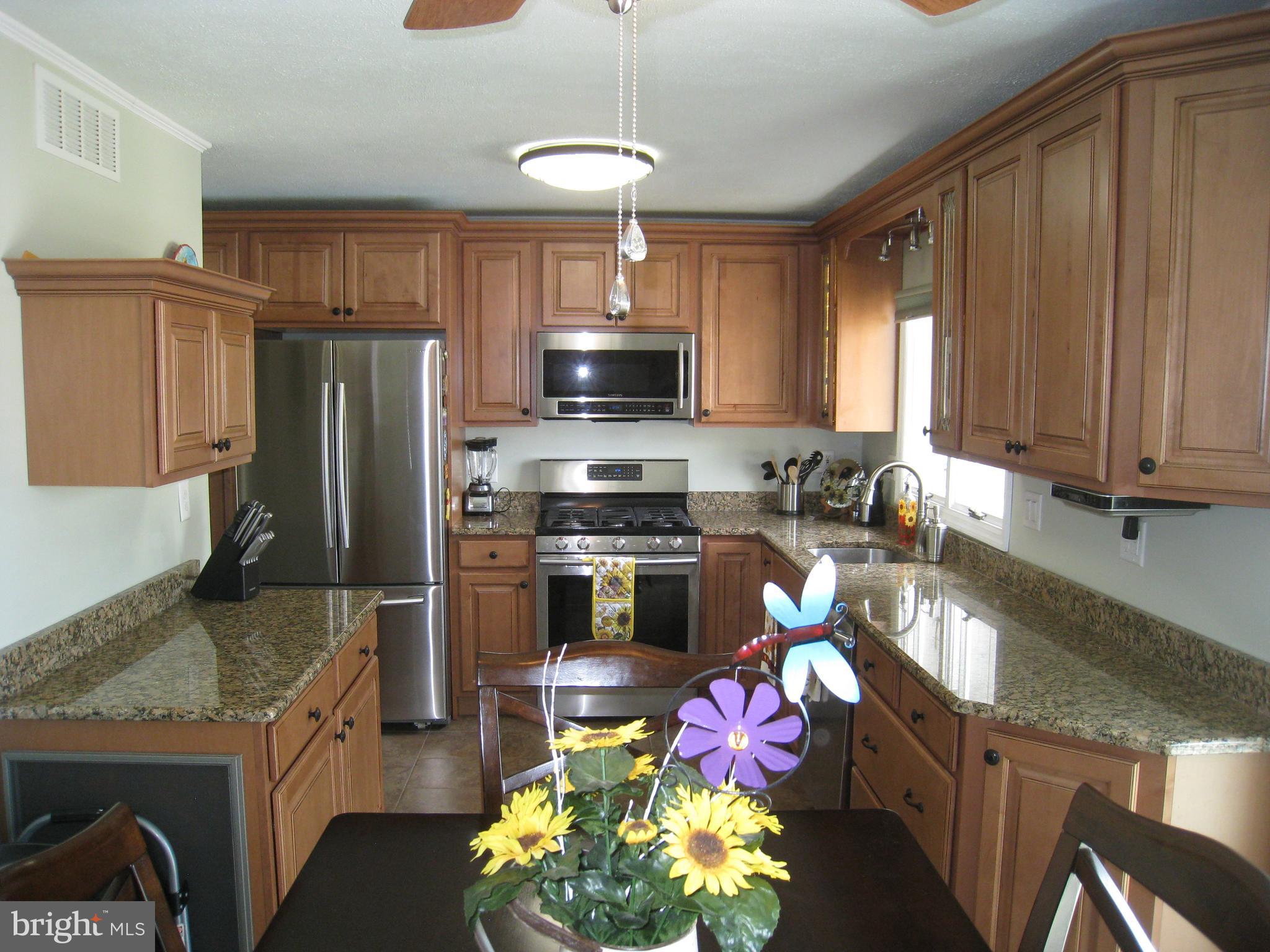 29 Buttonwood Road Stratford, NJ 08084 - Photo 23 of 45 a kitchen with granite countertop a stove top oven a refrigerator and a sink
