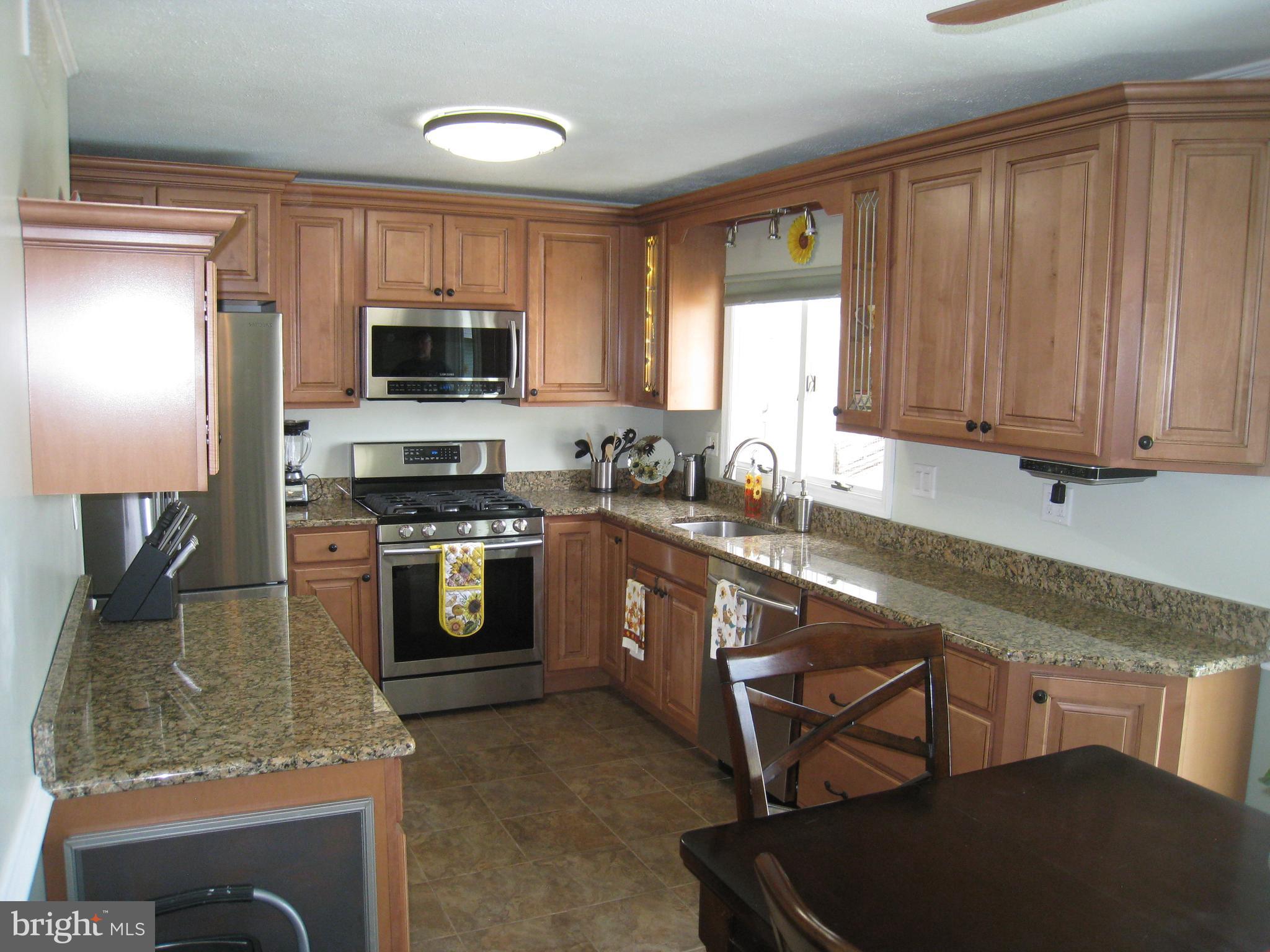 29 Buttonwood Road Stratford, NJ 08084 - Photo 24 of 45 a kitchen with stainless steel appliances granite countertop a stove a sink dishwasher and a microwave oven with cabinets