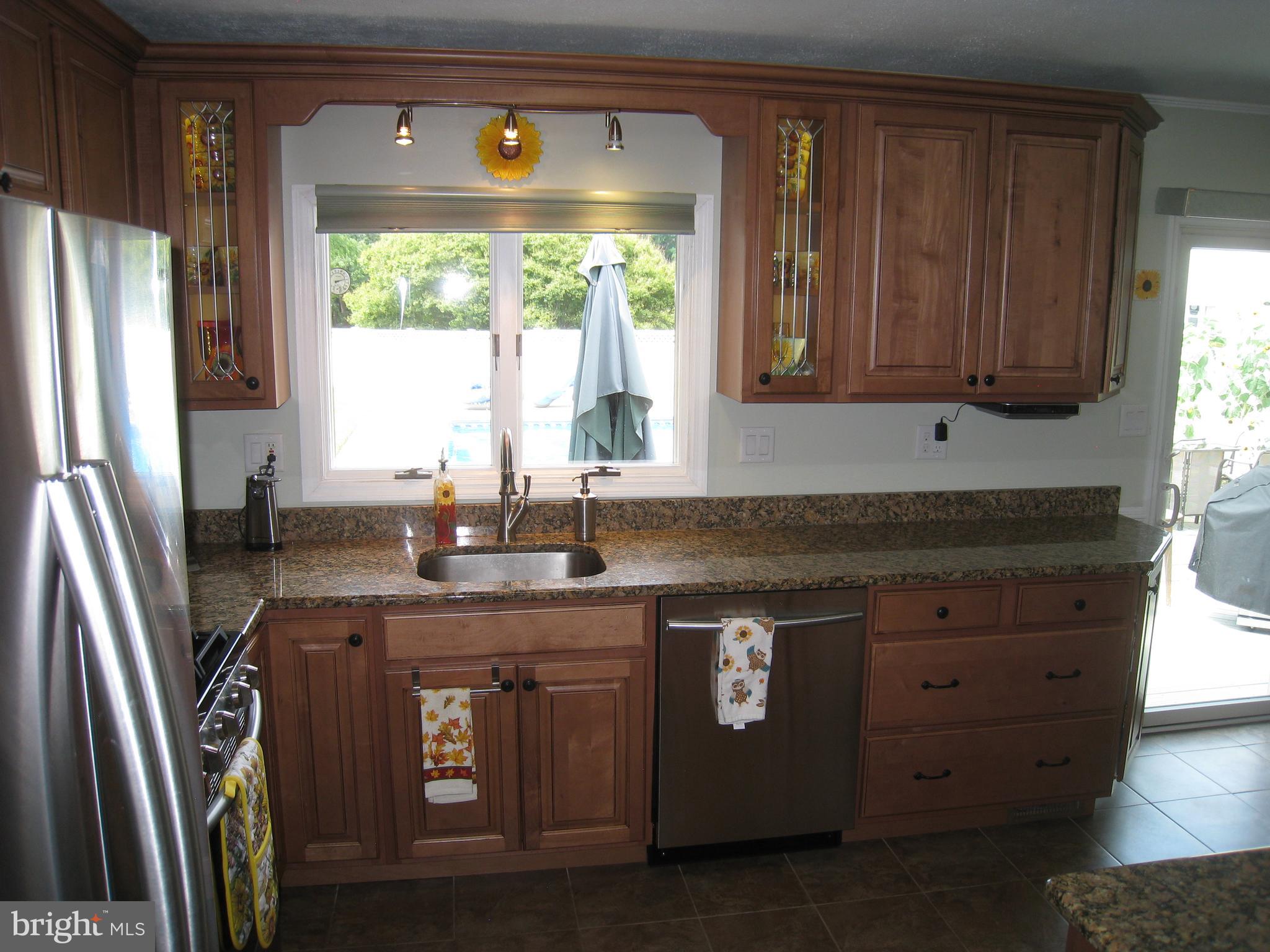 29 Buttonwood Road Stratford, NJ 08084 - Photo 25 of 45 a kitchen with stainless steel appliances granite countertop a stove a refrigerator a sink a window and wooden cabinets
