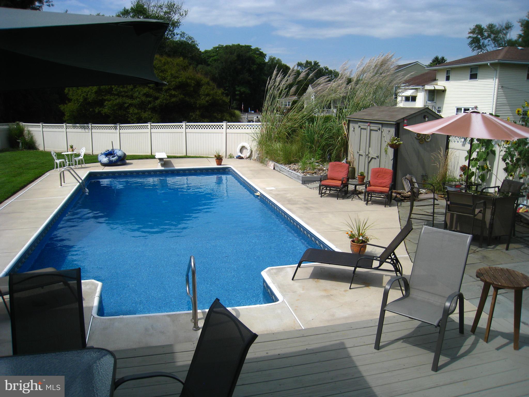 29 Buttonwood Road Stratford, NJ 08084 - Photo 7 of 45 a view of a patio with couches table and chairs under an umbrella with a barbeque grill