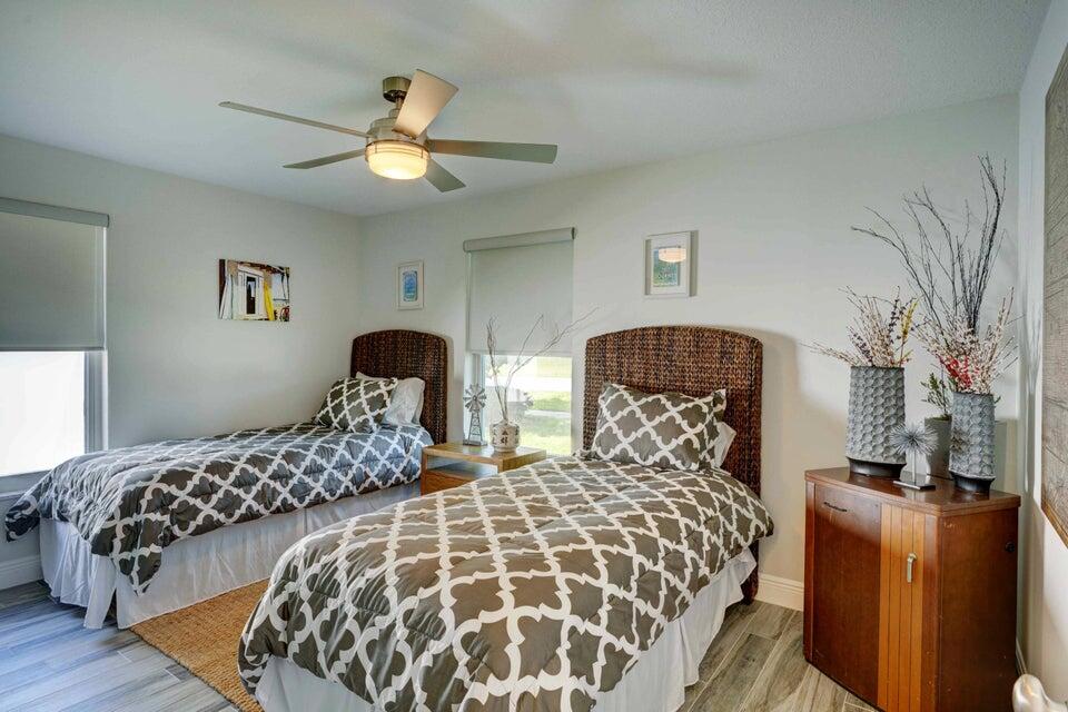 2594 Marcinski Road Jupiter, FL 33477 - Photo 3 of 10 a bedroom with two large bed and a chandelier