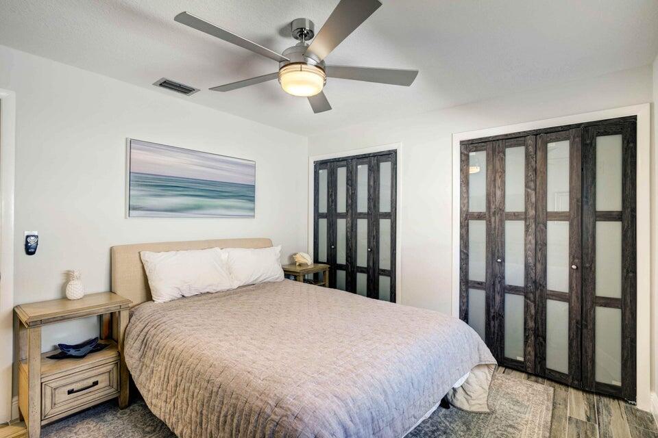 2594 Marcinski Road Jupiter, FL 33477 - Photo 4 of 10 a bedroom with a large bed and a chandelier
