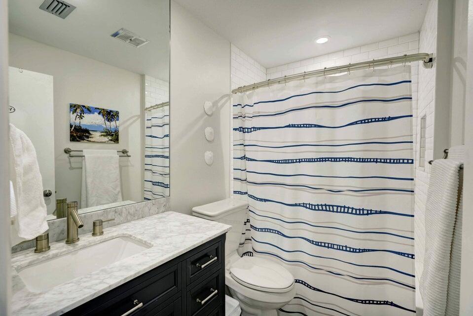 2594 Marcinski Road Jupiter, FL 33477 - Photo 5 of 10 a bathroom with a granite countertop sink toilet and shower