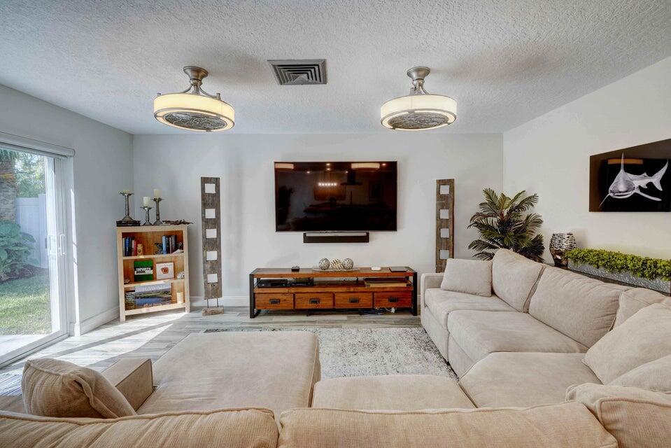 2594 Marcinski Road Jupiter, FL 33477 - Photo 7 of 10 a living room with furniture and a flat screen tv
