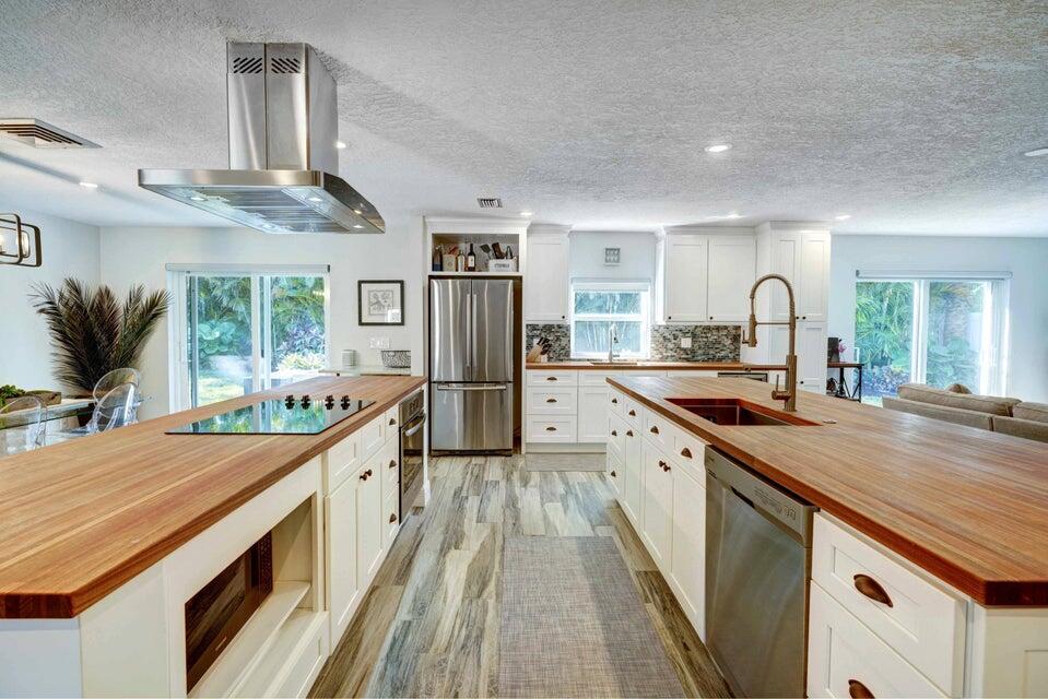 2594 Marcinski Road Jupiter, FL 33477 - Photo 8 of 10 a large kitchen with stainless steel appliances granite countertop a lot of counter space and wooden floors