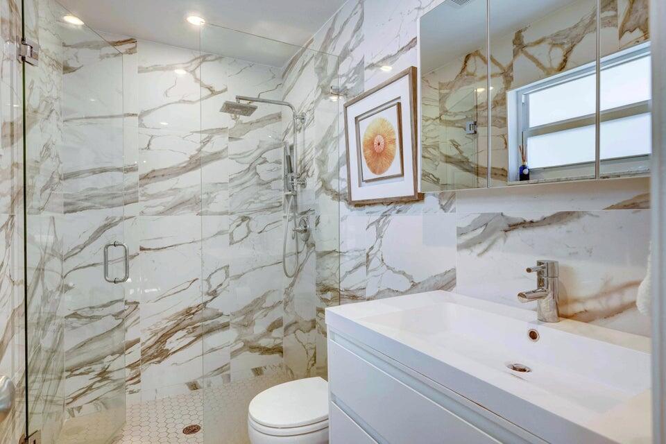 2594 Marcinski Road Jupiter, FL 33477 - Photo 9 of 10 a bathroom with a sink a toilet and shower