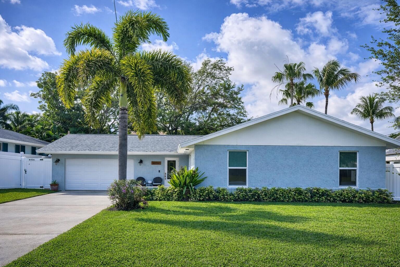 2594 Marcinski Road Jupiter, FL 33477 - Photo 10 of 10 a front view of a house with a yard and garage