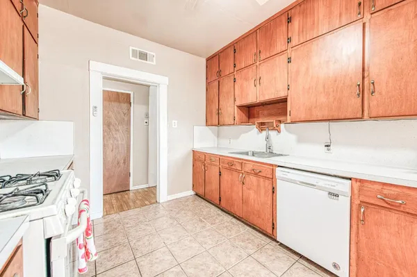 a kitchen with stainless steel appliances a sink stove and cabinets