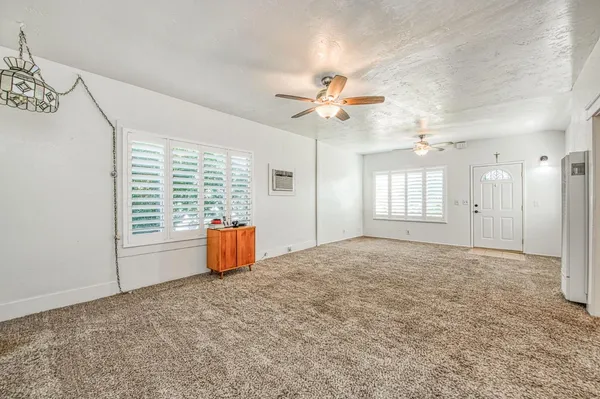 en empty room with windows and ceiling fan