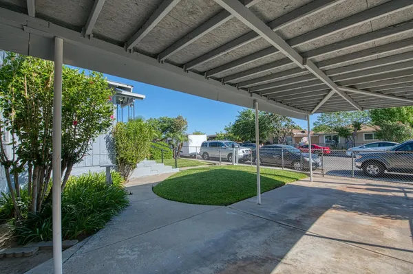 a view of a backyard with couches under an umbrella