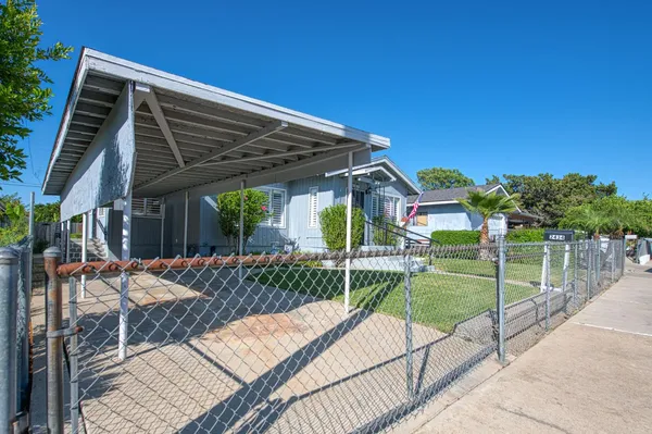 a view of backyard with table and chairs and wooden fence