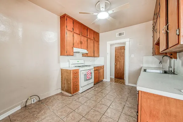 a kitchen with stainless steel appliances granite countertop a sink a stove cabinets and wooden floor