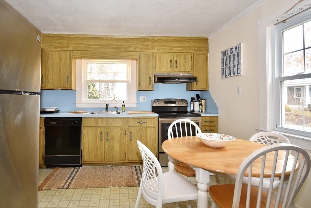 460 Williston Road Bourne, MA 02562 - Photo 17 of 37 a kitchen with stainless steel appliances granite countertop a sink a stove a refrigerator a dining table and chairs with wooden floor
