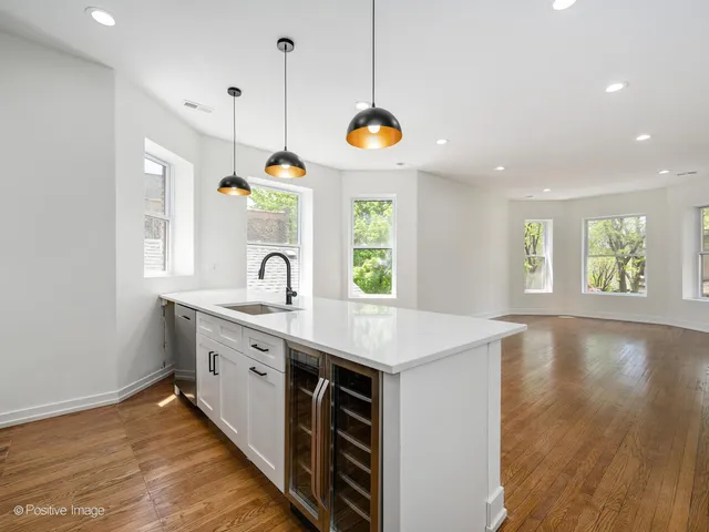 a kitchen with a sink stove and wooden floor