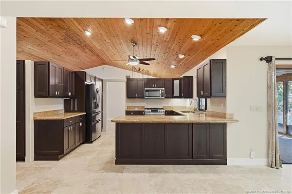 a kitchen with stainless steel appliances granite countertop a stove sink and refrigerator