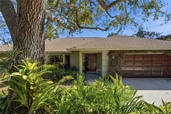 a view of a house with a tree in the yard