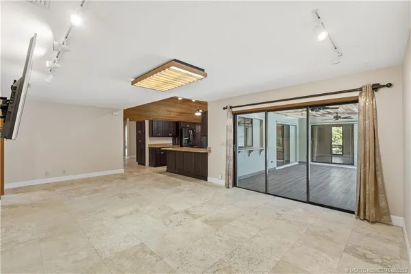 an empty room with window and ceiling fan