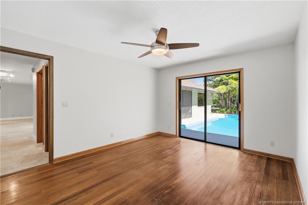 5186 Southeast Harrold Terrace Stuart, FL 34997 - Photo 23 of 50 an empty room with wooden floor and windows