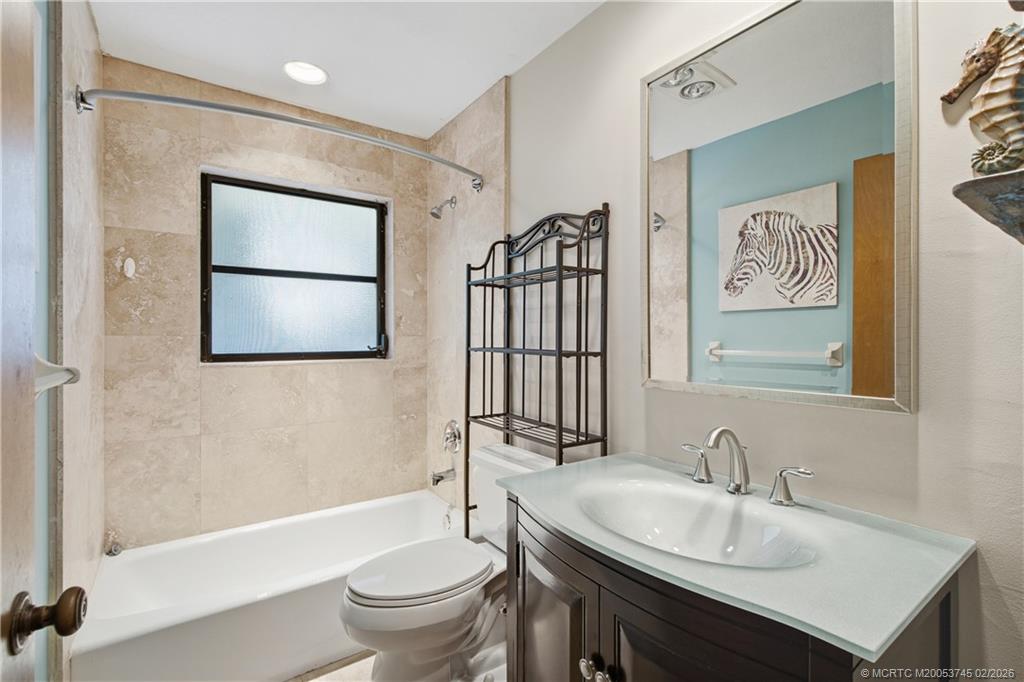 5186 Southeast Harrold Terrace Stuart, FL 34997 - Photo 27 of 50 a bathroom with a sink a toilet and shower