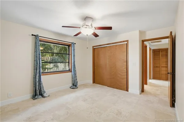 a view of a livingroom with a chandelier fan and windows