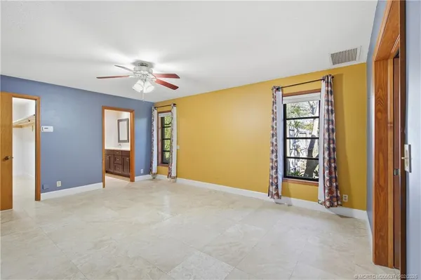 a view of empty room with window and ceiling fan