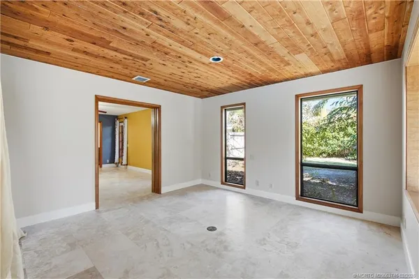 a view of an empty room with wooden floor and door