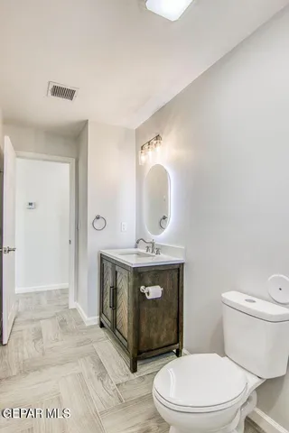 a view of bathroom with a toilet sink and mirror