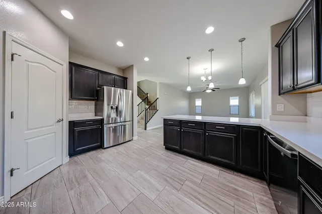 a large kitchen with a large counter top space stainless steel appliances and cabinets