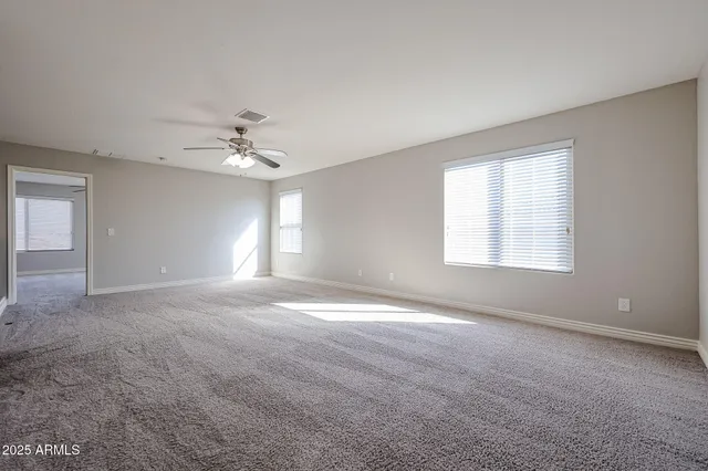 a view of a livingroom with a ceiling fan and window