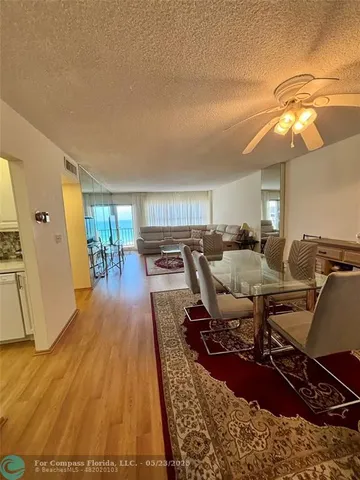 a living room with lots of chairs and a dining table with wooden floor