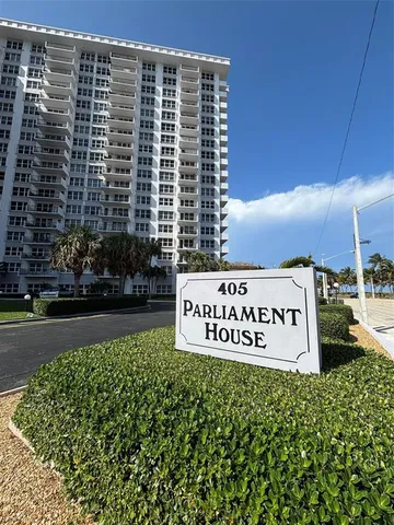 a sign board with buildings in the background