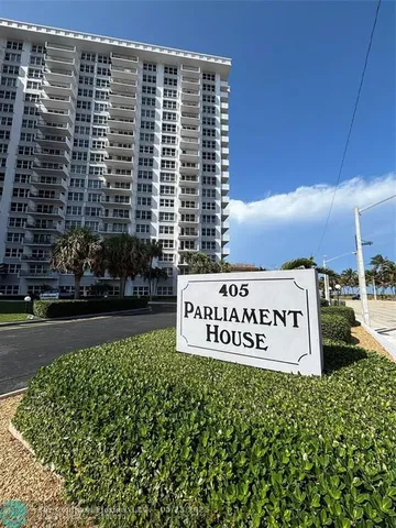 a sign board with buildings in the background