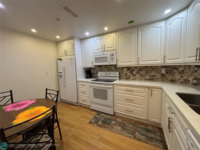 a bedroom with a bed a mirror on dresser and a flat screen tv