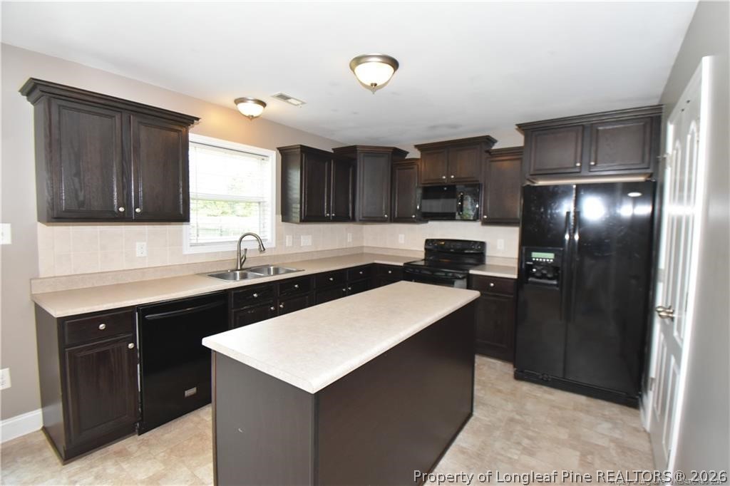131 South Prince Henry Way Cameron, NC 28326 - Photo 5 of 26 a kitchen with a sink a stove a refrigerator a kitchen island and chairs