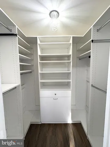a view of walk in closet with empty racks