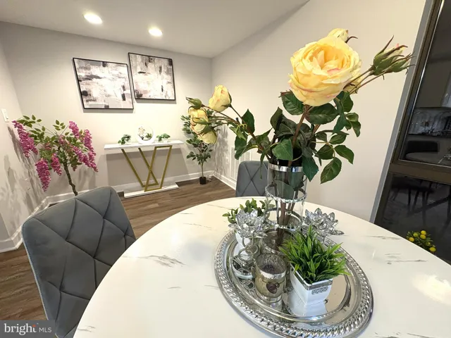 a view of a dining room with furniture a potted plant and wooden floor