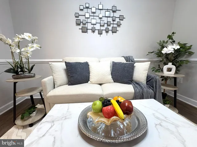 a living room with furniture flowerpot and a chandelier